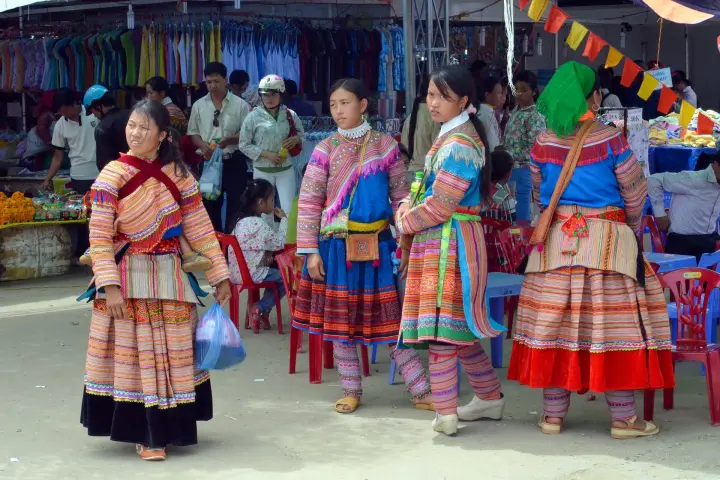 Flower Hmong women in embroidered dress at a market in Lào Cai