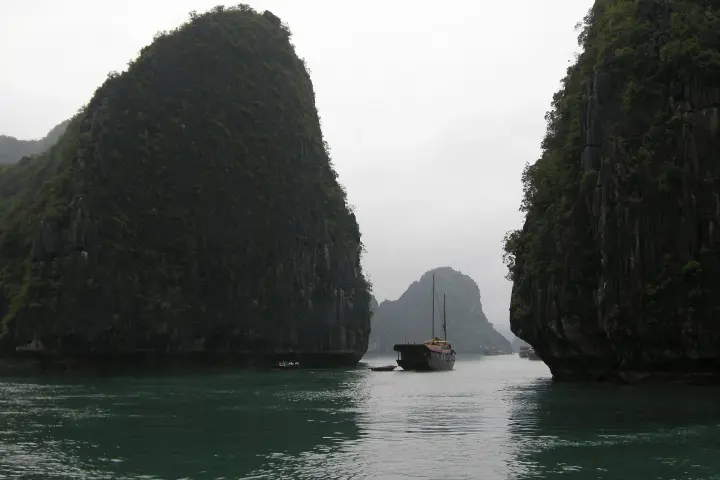 Limestone islets and a junk boat in Hạ Long Bay