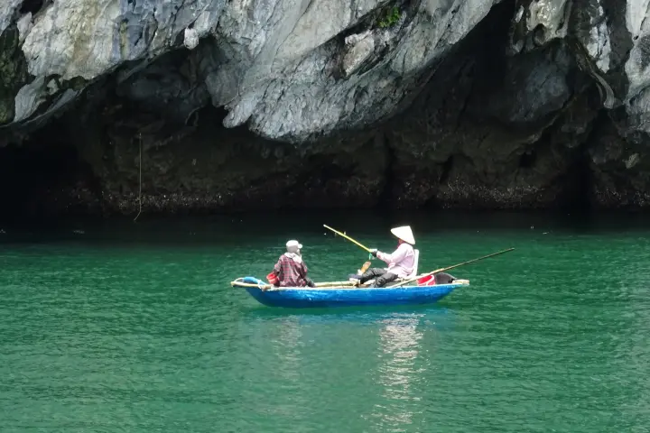 A rowing boat in a turquoise sea cave in Lan Hạ Bay